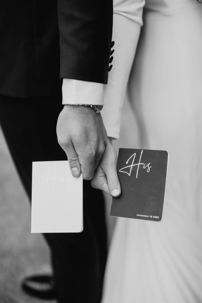 Bride and groom hold their vow books 