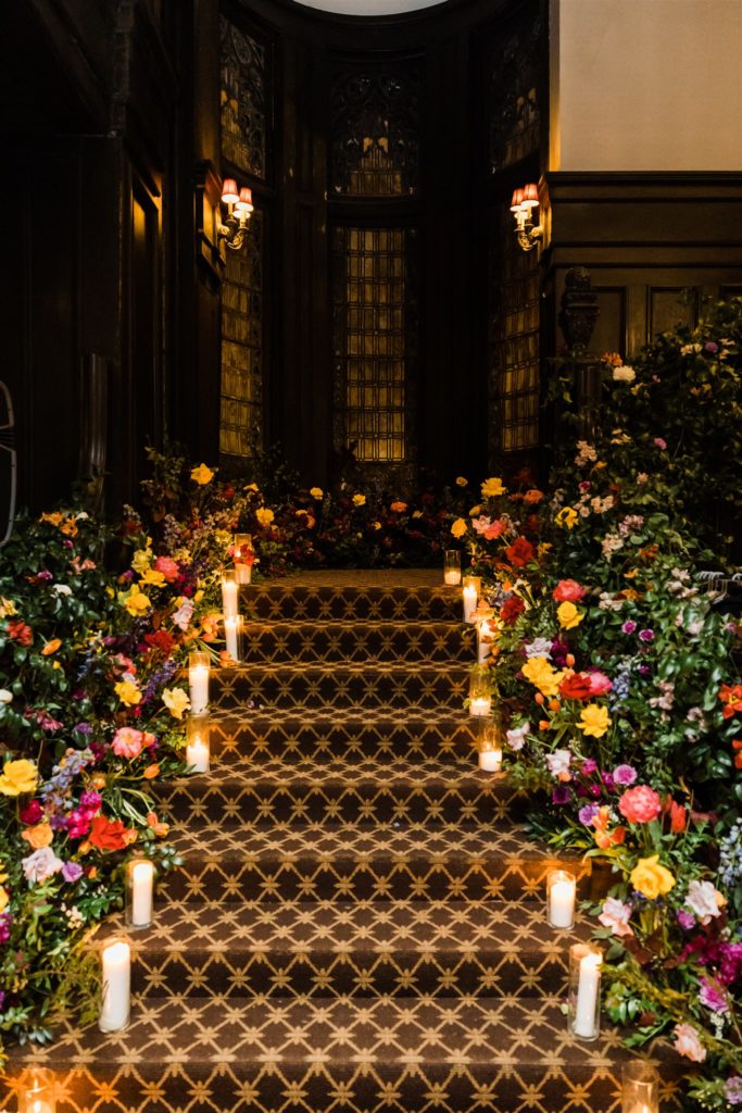 Steps adorned with candles and florals inside the Mansions on Fifth wedding