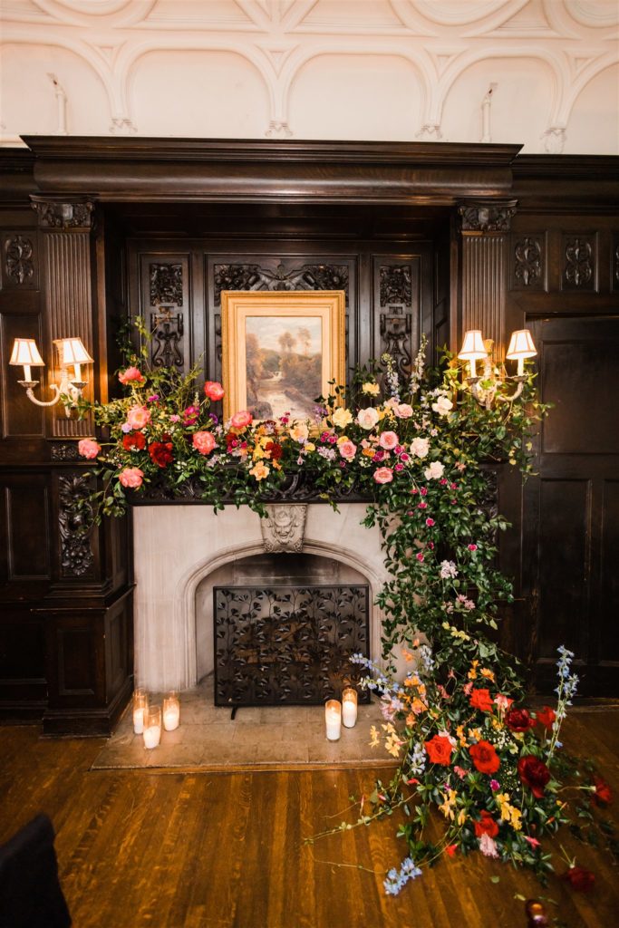 Fireplace decorated with roses and greenery inside the Mansions on Fifth hotel