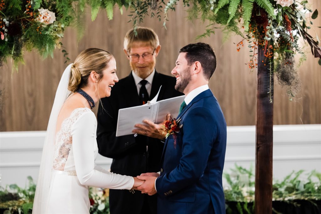 Bride and groom laugh together as they say their vows at their Graduate Hotel fall wedding