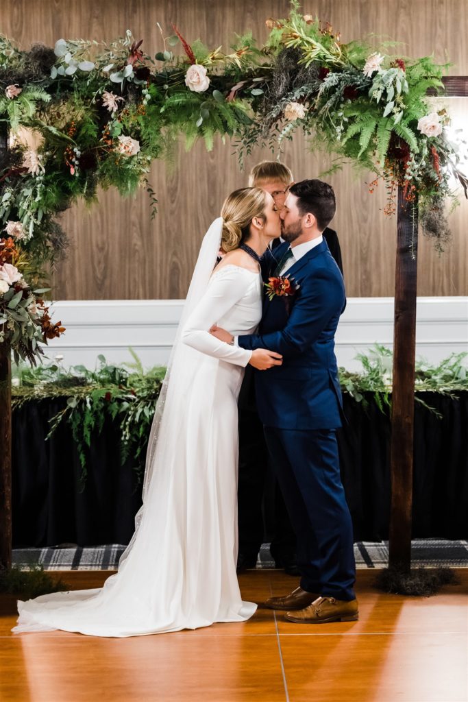 Bride and groom kiss after saying their vows at their Graduate Hotel fall wedding
