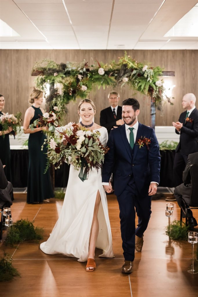 bride and groom walk up the aisle after their Graduate Hotel fall wedding