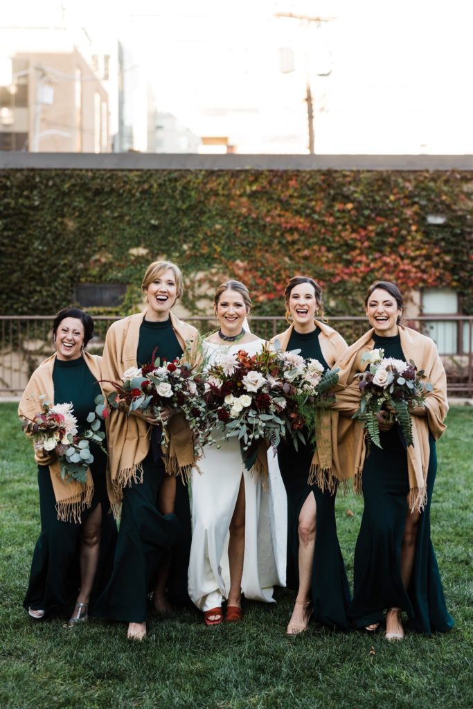 Bride and bridesmaids pose outside their Graduate Hotel fall wedding
