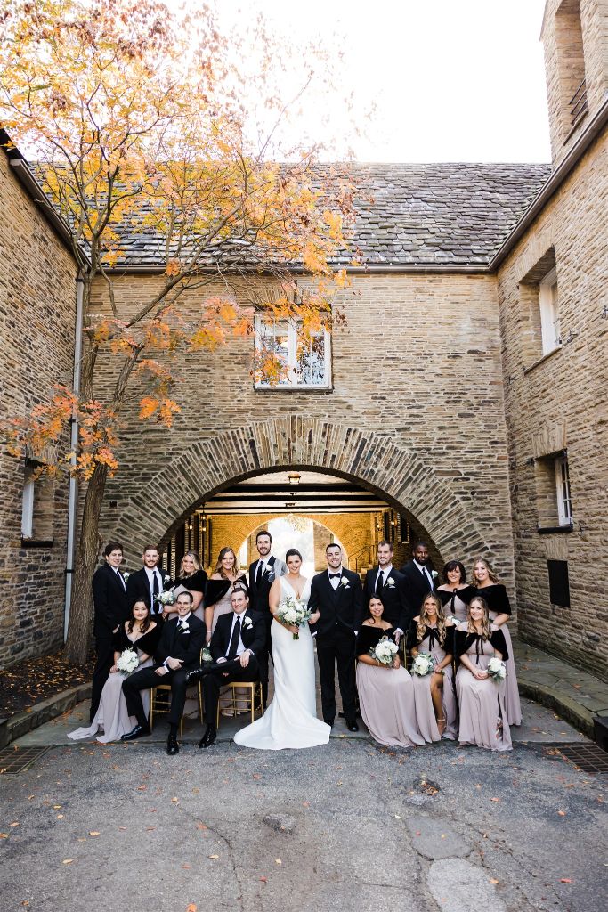 Bridal party poses in the archway of Longue Vue club