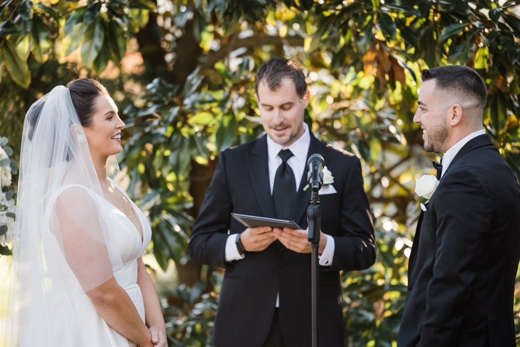 Bride and groom exchange vows at wedding at Longue Vue Club