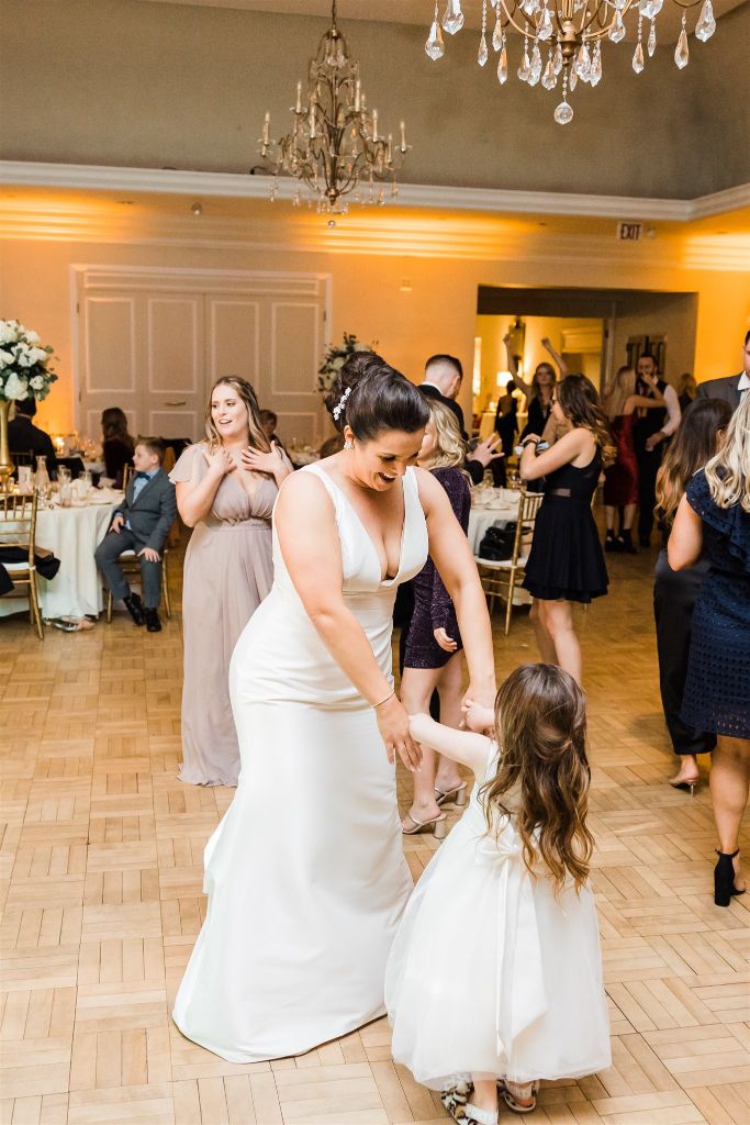 bride dances with flower girl at wedding reception