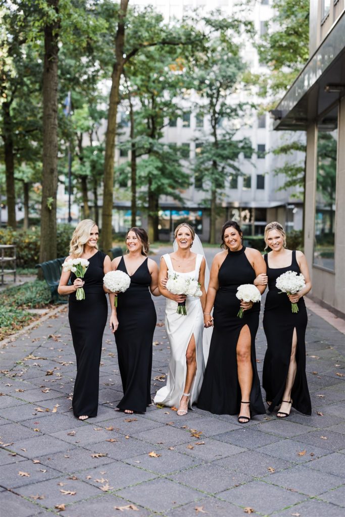 Bride and bridesmaids pose together outside PPG