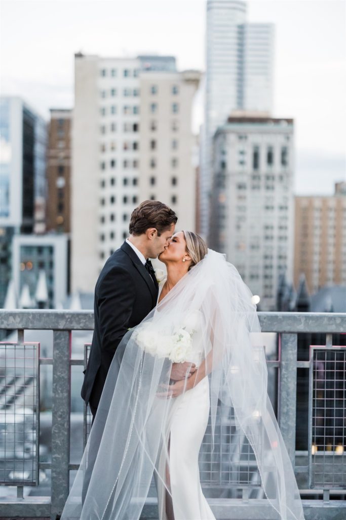 Bride and groom kiss on rooftop in Pittsburgh