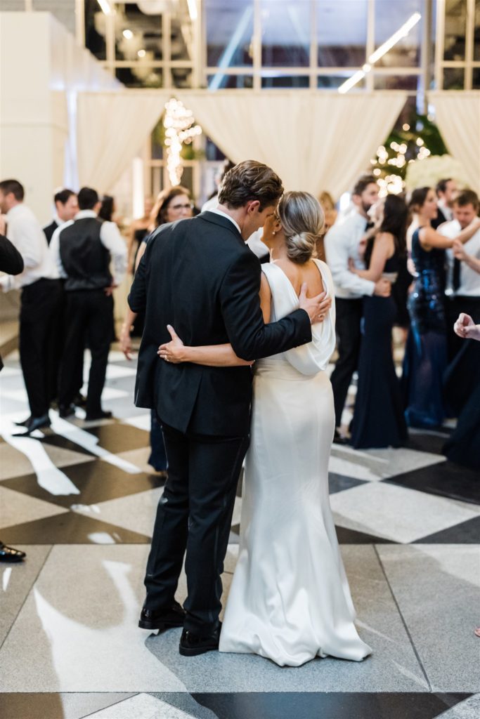 bride and groom hug on the dance floor of their black and white PPG wedding