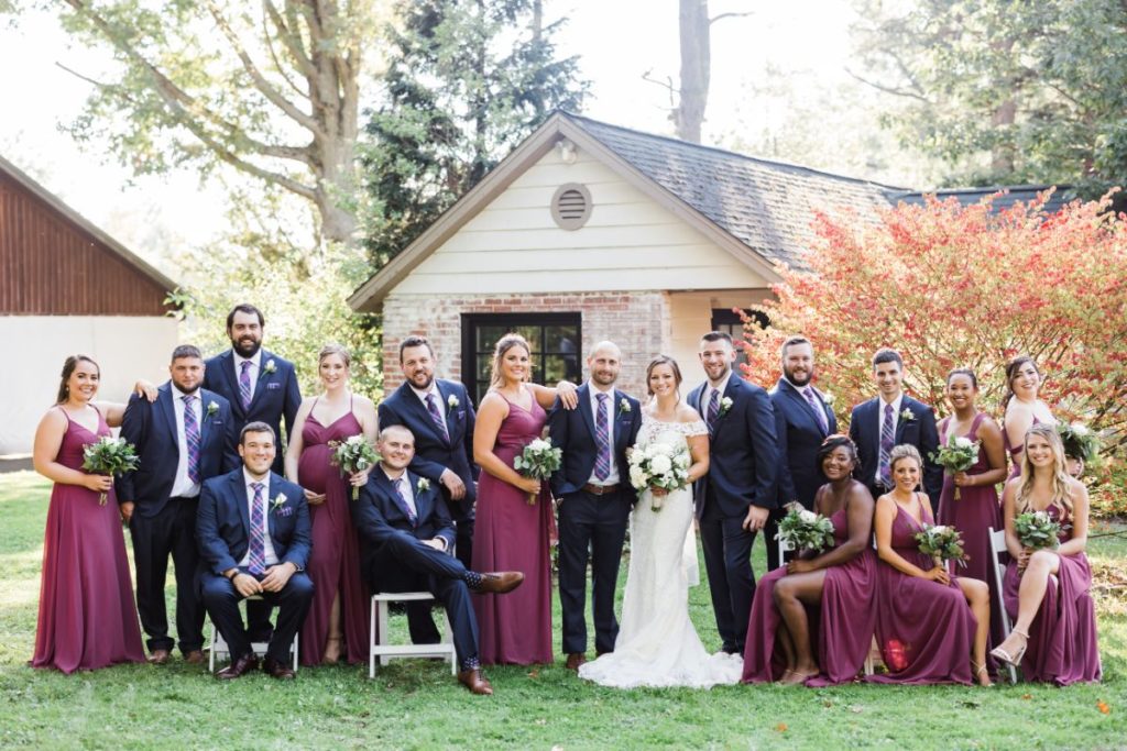 Large bridal party poses together on the grounds of Succop Nature Park