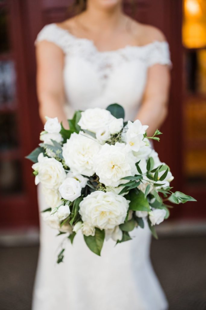 Bride holds white and green wedding bouquet
