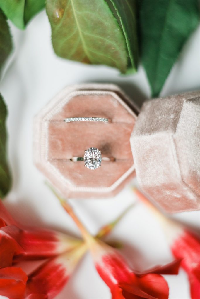Wedding and engagement ring in blush pink box surrounded by flowers