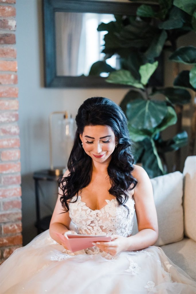 Bride smiles as she reads letter from groom