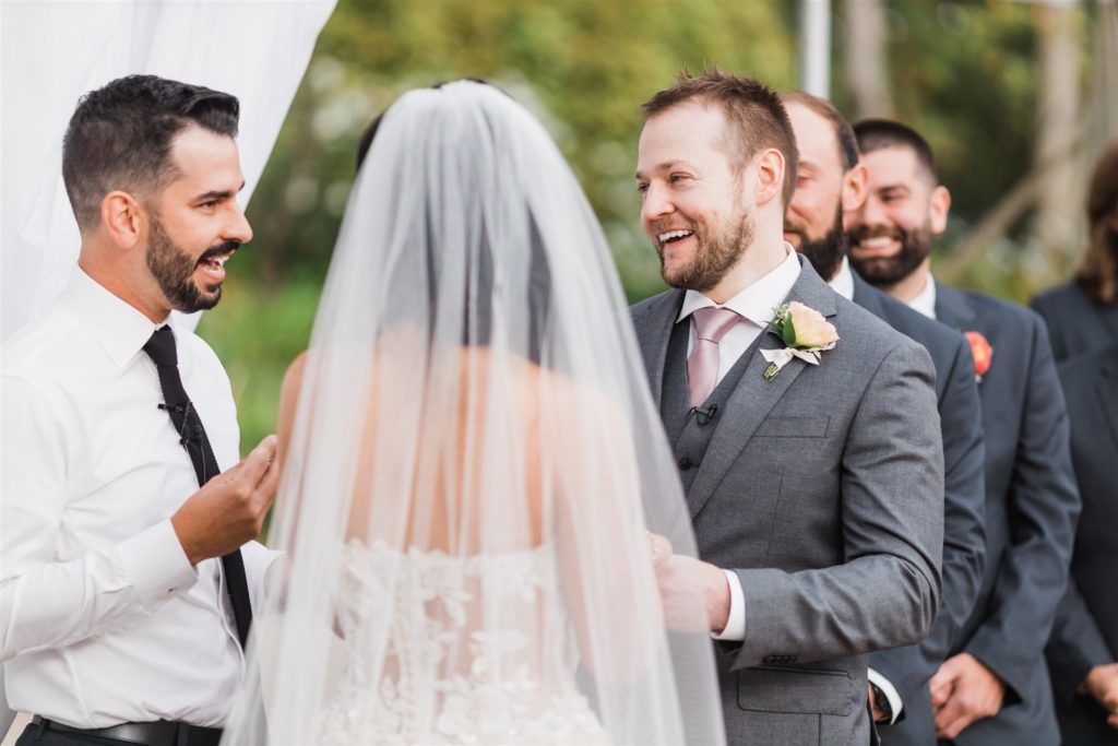 Groom laughs as he says his vows at a Fall Frick Pittsburgh wedding