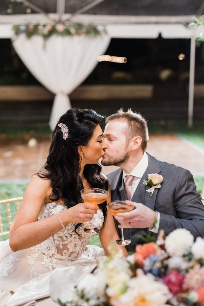 Bride and groom toast and kiss at their Fall Frick Pittsburgh Wedding reception