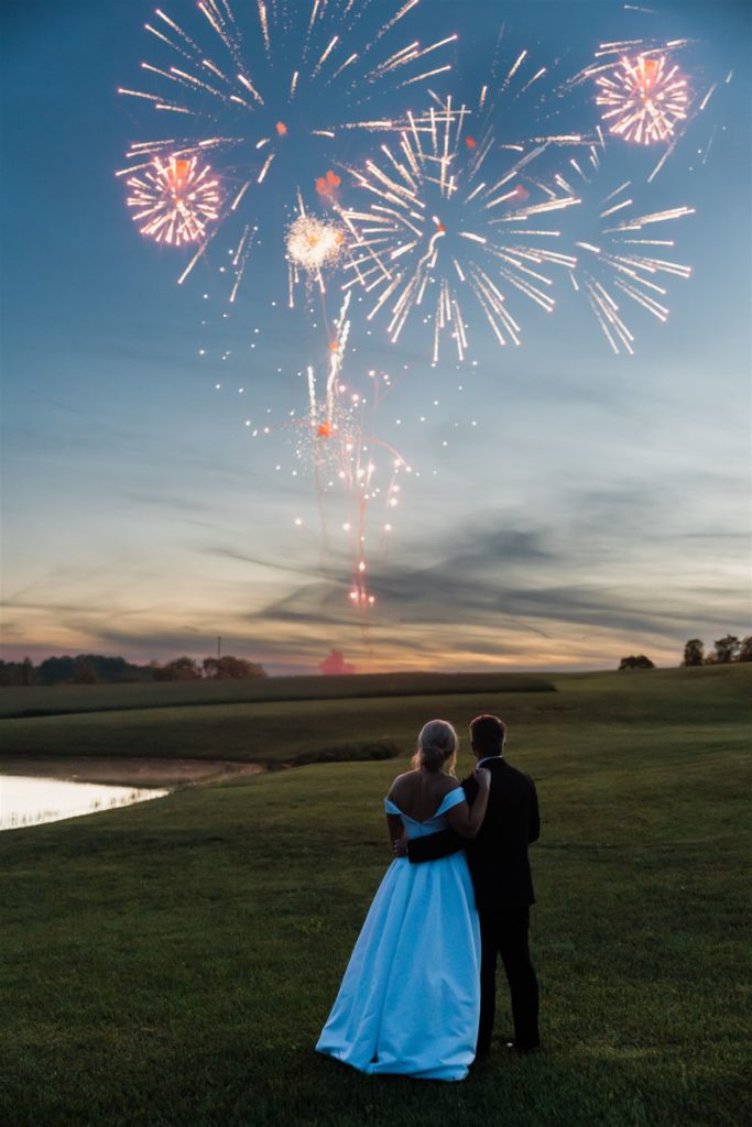 Bride and groom watch fireworks outside their wedding at White Barn
