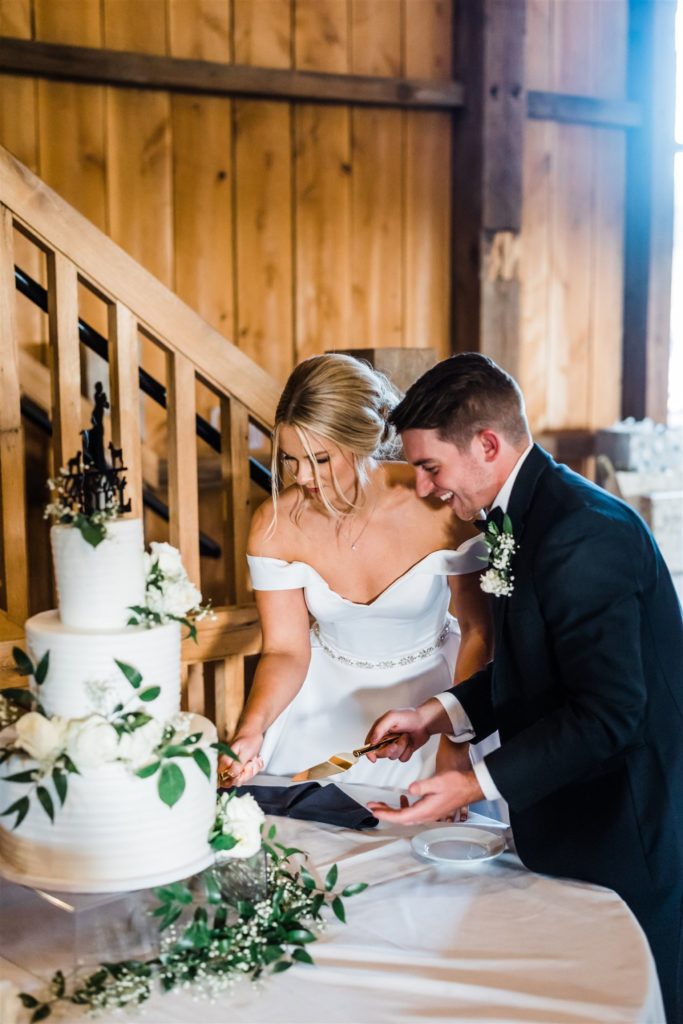 Bride and Groom cut their cake at the White Barn