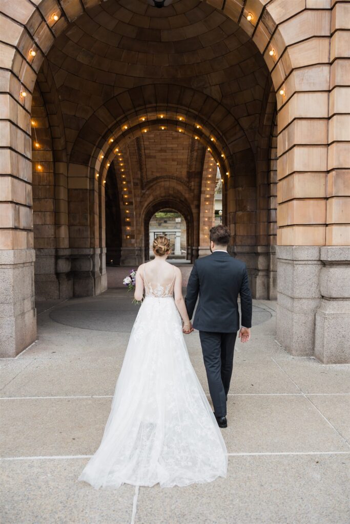 Bride and groom walk under archways at fall Pennsylvanian wedding