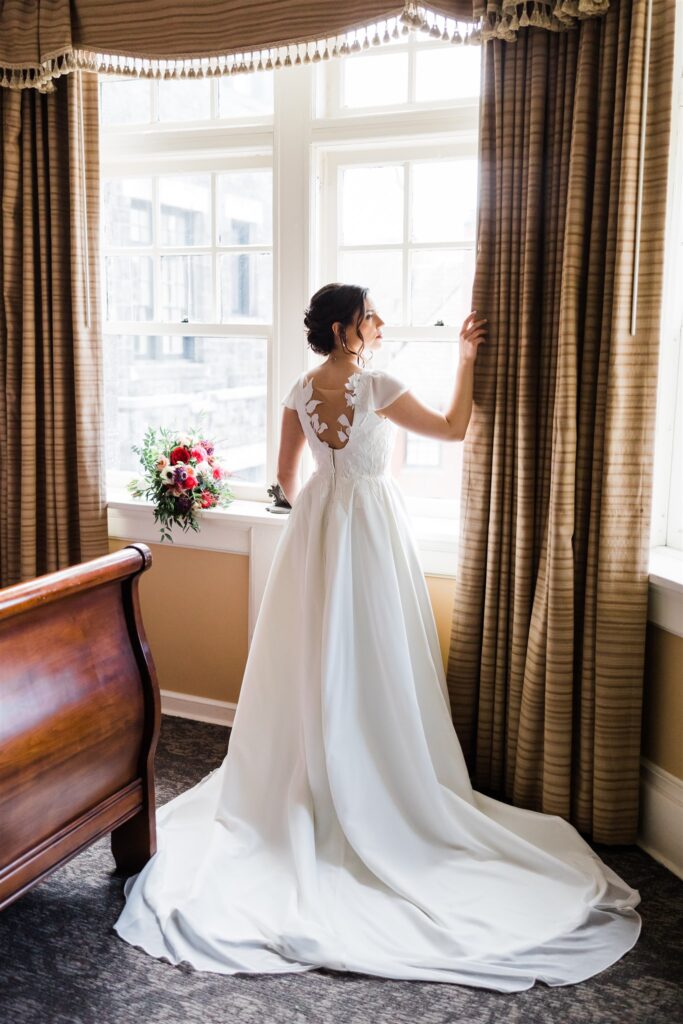 Bride stands in window at Winter Wedding at the Mansions on Fifth